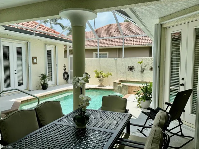 View of patio with french doors, outdoor dining space, and a sunroom