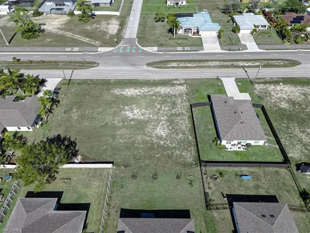 Aerial view of property and surrounding area with nearby suburban area