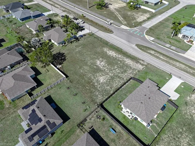 Aerial view of property and surrounding area featuring nearby suburban area