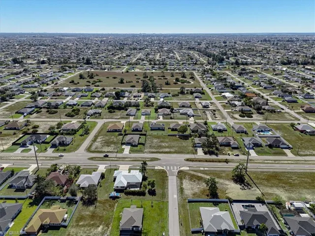 Aerial view of property and surrounding area with nearby suburban area