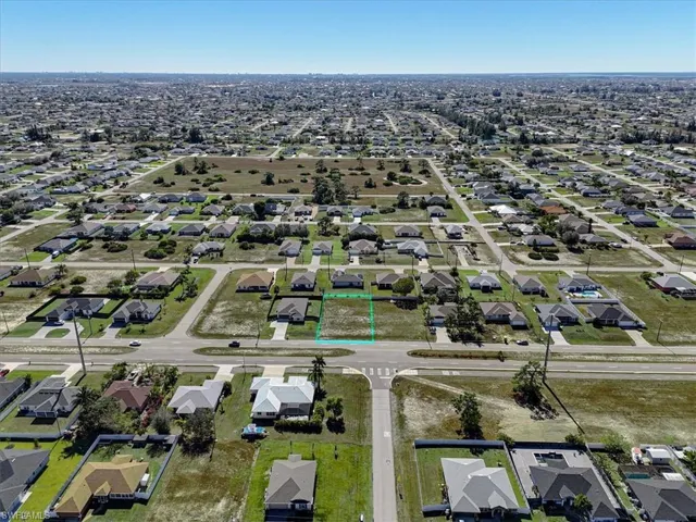 Aerial overview of property's location featuring nearby suburban area and property parcel outlined