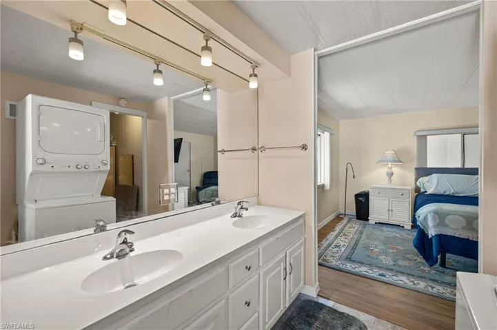 Bathroom with a sink, stacked washer / dryer, double vanity, and connected bathroom