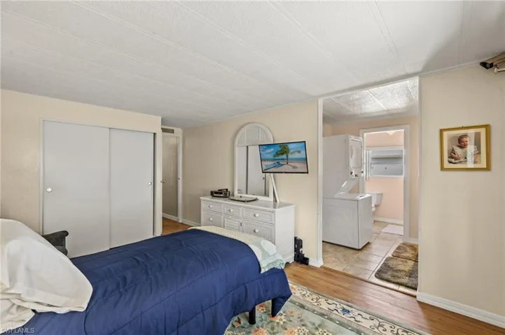 Bedroom with a closet, light wood-style flooring, and baseboards