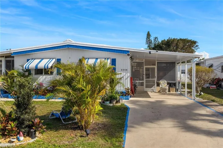Manufactured / mobile home with a front lawn, a sunroom, and concrete driveway