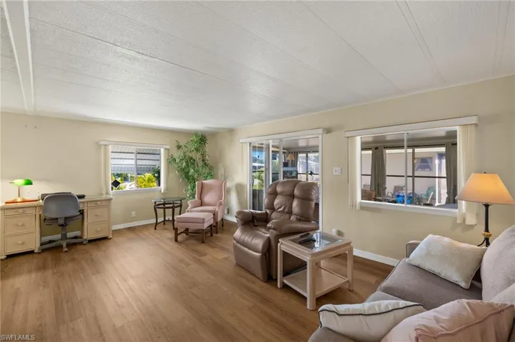 Living room with luxury vinyl flooring, baseboards, and a textured ceiling