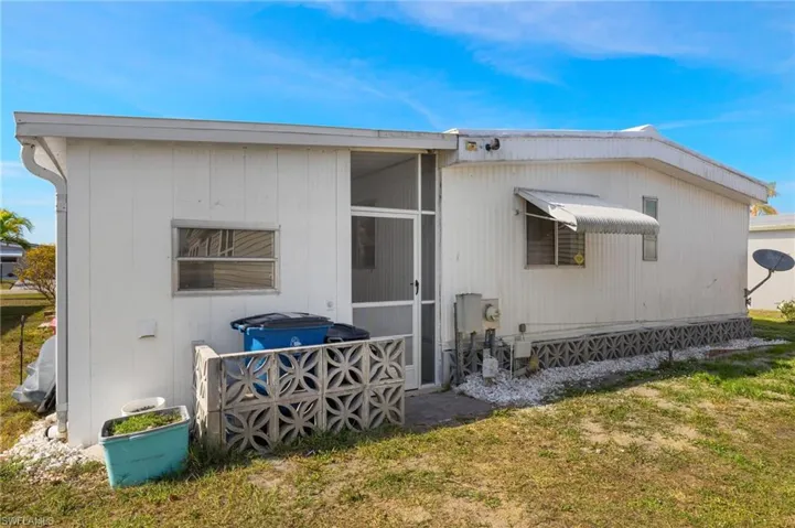 Rear view of property featuring a yard and a sunroom