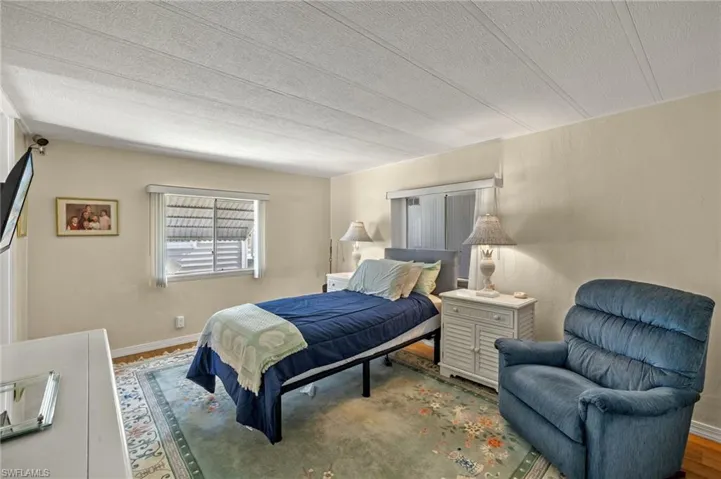 Bedroom featuring wood finished floors and baseboards