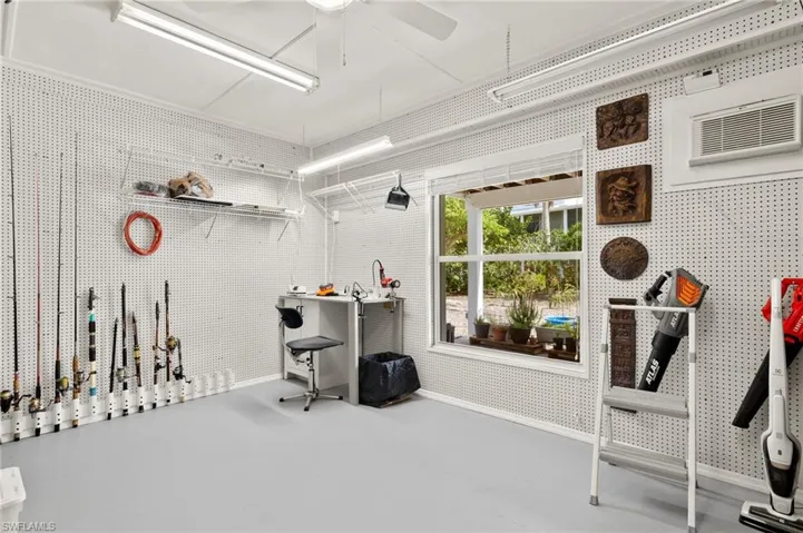 Miscellaneous room featuring concrete floors, a wall unit AC, and ceiling fan