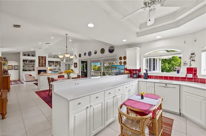 Kitchen featuring light tile patterned flooring, dishwasher, kitchen peninsula, and a healthy amount of sunlight