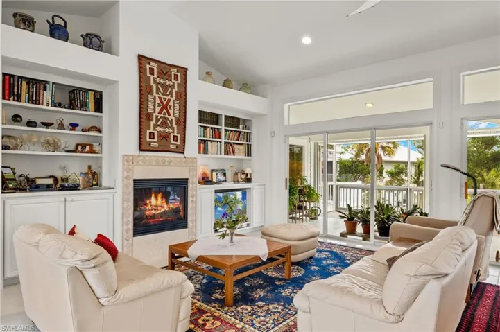 Living room with built in features and high vaulted ceiling