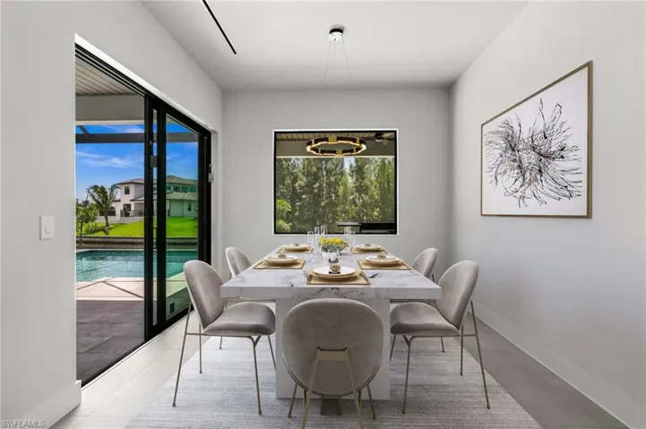 Dining area featuring a marble-finish table and contemporary chandelier