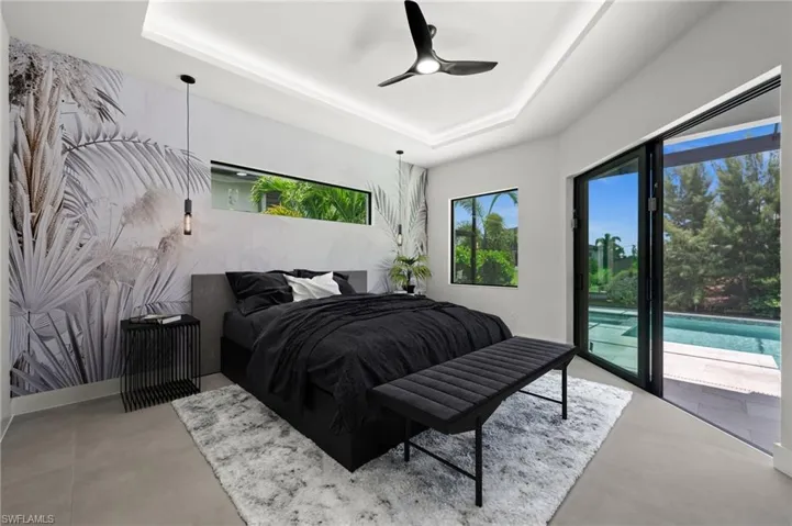 Spacious room with tray ceiling, modern ceiling fan, and large format tile flooring