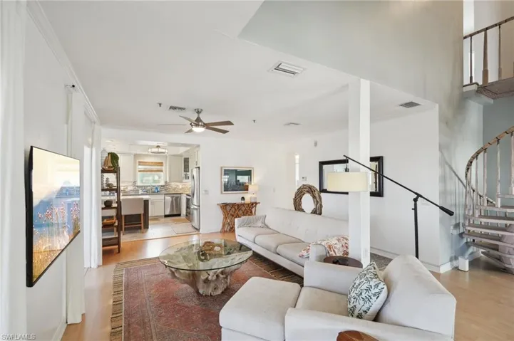 Living room with light hardwood / wood-style floors, ornamental molding, and ceiling fan