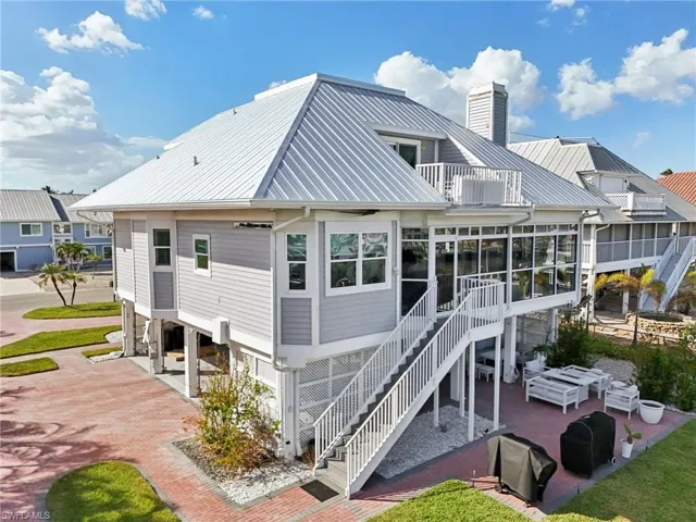 Back of property featuring a carport and a sunroom