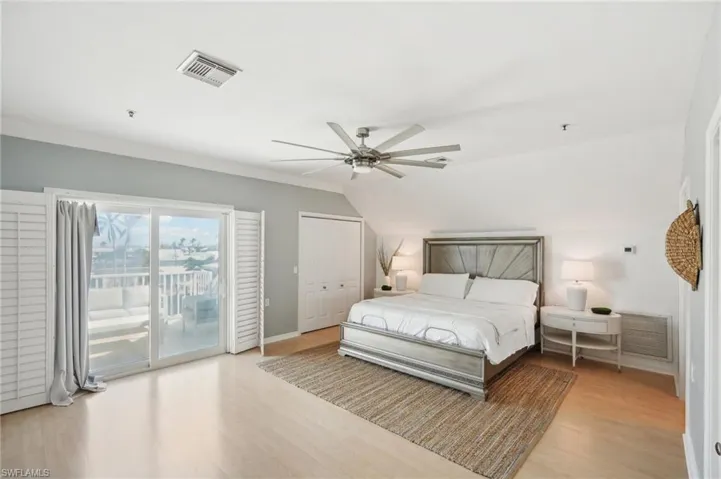 Bedroom featuring a closet, light hardwood / wood-style floors, access to outside, and ceiling fan