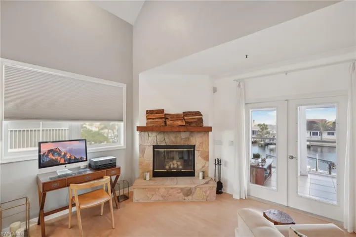 Office space with a wealth of natural light, french doors, and light hardwood / wood-style flooring