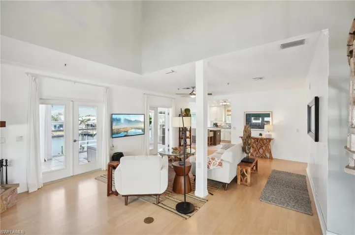 Living room with light hardwood / wood-style floors, french doors, and ceiling fan