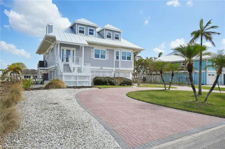 View of front of house featuring covered porch, a front yard, and a garage