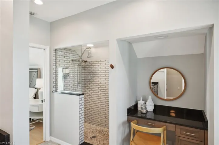 Bathroom featuring a tile shower, hardwood / wood-style flooring, and vanity