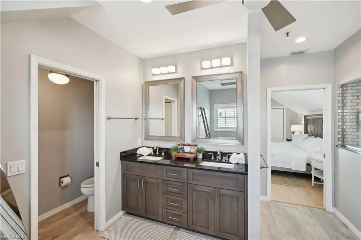 Bathroom featuring vanity, toilet, ceiling fan, and hardwood / wood-style floors