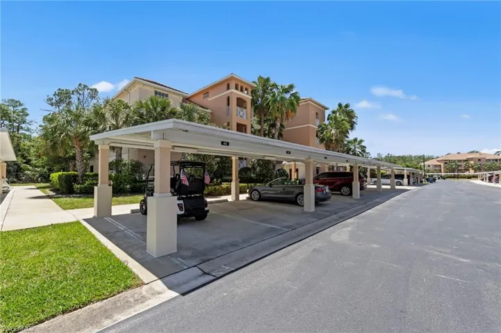 Covered parking spaces are available, with a paved driveway and landscaped grass areas