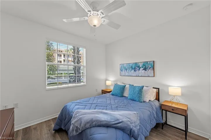This room features a ceiling fan, a window with blinds, and wood-style flooring