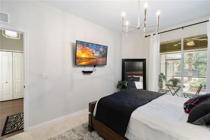 Bedroom featuring visible vents, baseboards, an inviting chandelier, and carpet floors