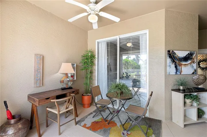 Dining space featuring tile patterned floors, ceiling fan, and a textured wall