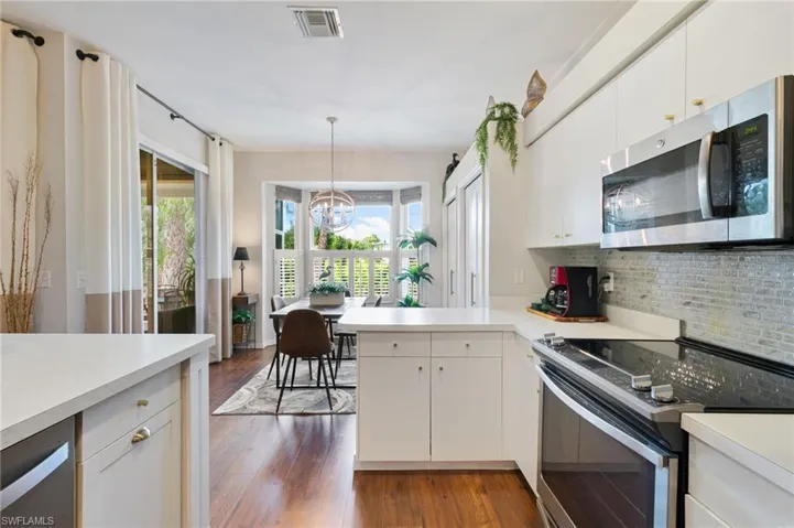 Kitchen featuring tasteful backsplash, visible vents, light countertops, and appliances with stainless steel finishes