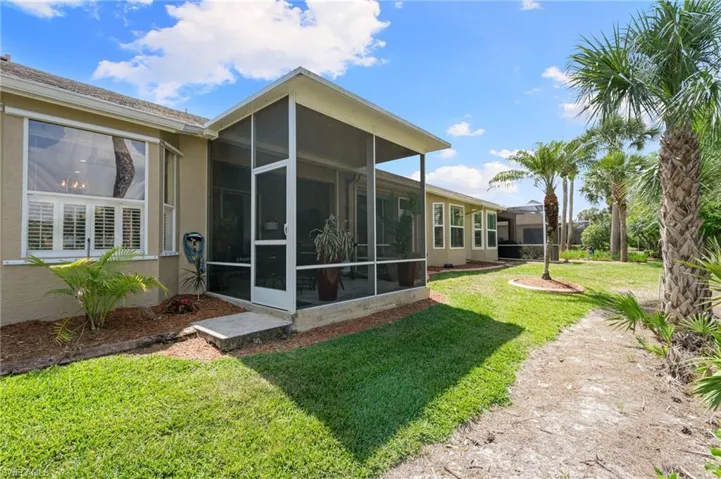 Back of property with stucco siding and a lawn