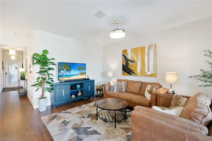 Living area with visible vents, baseboards, and dark wood finished floors