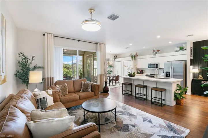 Living room featuring visible vents, recessed lighting, and dark wood finished floors