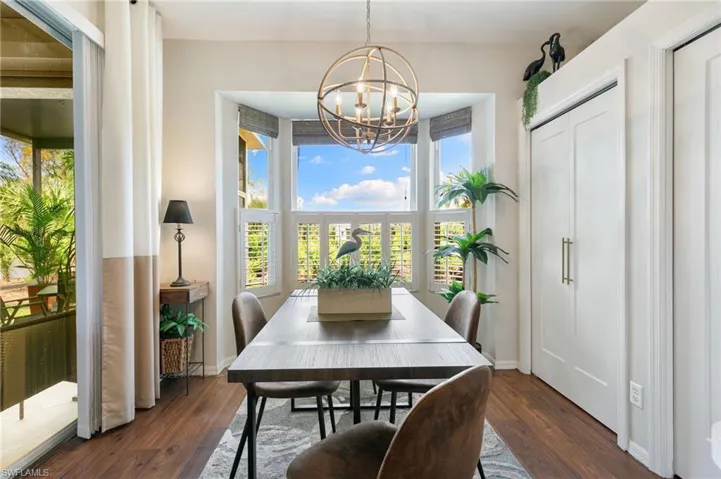 Dining room with a chandelier, plenty of natural light, and dark wood-style floors
