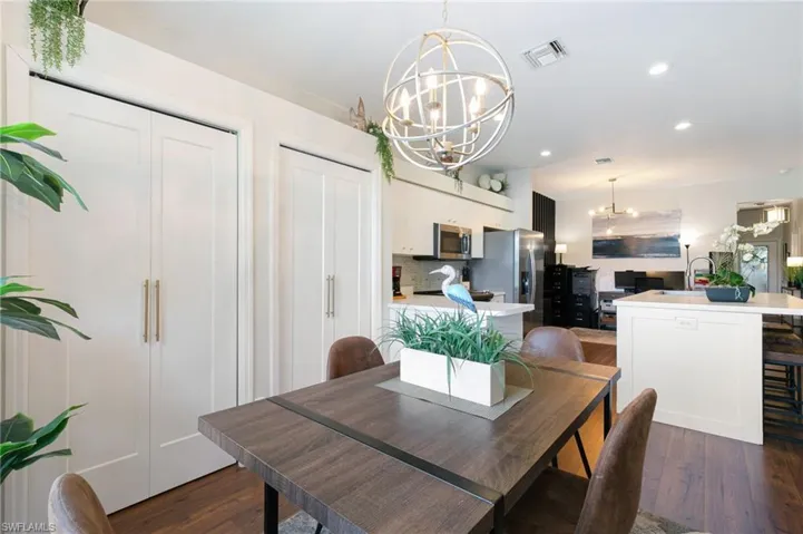 Dining room with visible vents, recessed lighting, an inviting chandelier, and dark wood-style floors