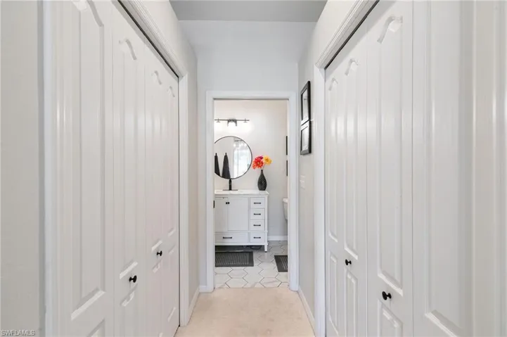 Hall featuring light tile patterned floors and baseboards