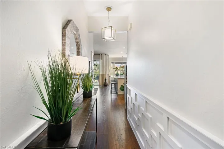 Corridor featuring wainscoting and dark wood-style floors