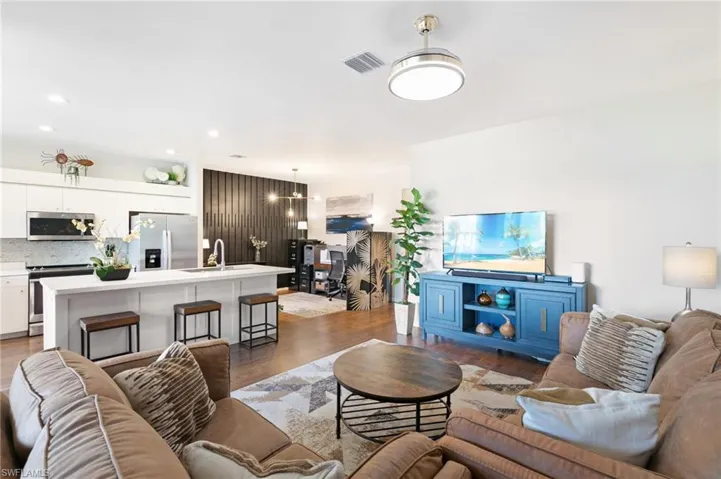 Living area with light wood-style floors, visible vents, and recessed lighting