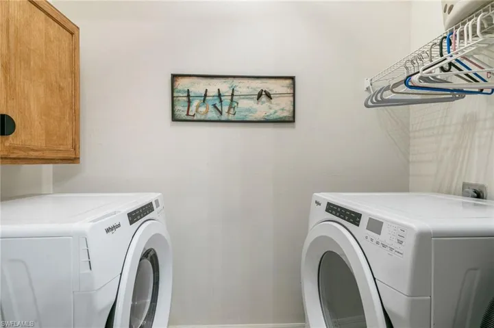 Washroom featuring cabinet space and washing machine and dryer