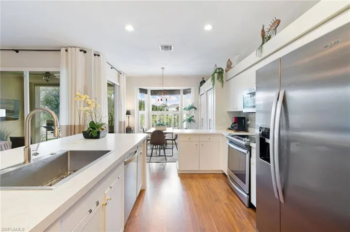 Kitchen featuring a sink, light countertops, appliances with stainless steel finishes, recessed lighting, and light wood finished floors