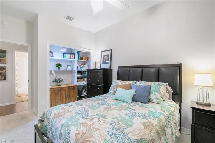 Carpeted bedroom with visible vents, baseboards, and ceiling fan