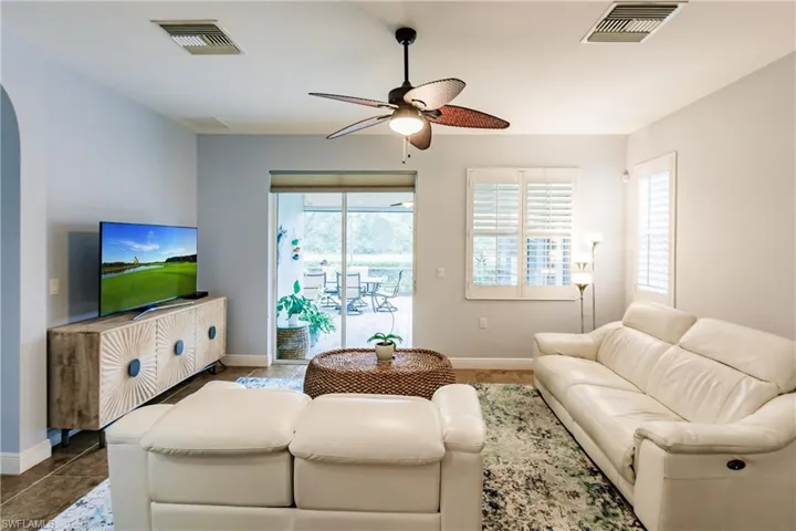 OPEN CONCEPT LIVING ROOM WITH PLANTATION SHUTTERS, UPDATED FAN W/LIGHTING & PRIVACY SUN SCREEN!