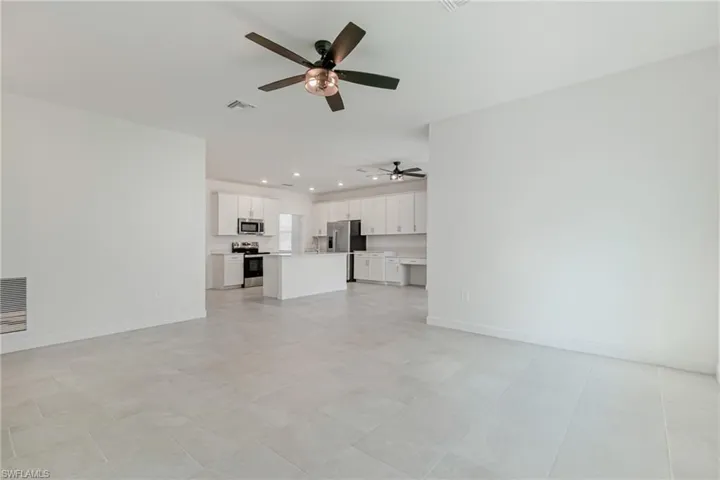 Unfurnished living room with ceiling fan and recessed lighting