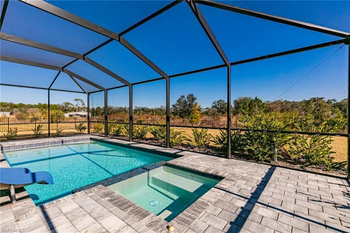 Integrated pool / hot tub with glass enclosure, a sunroom, and a water slide