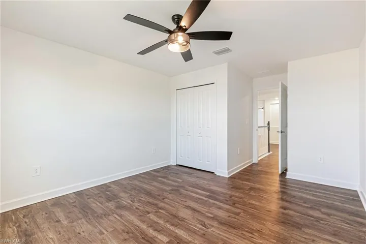 Unfurnished bedroom featuring dark wood finished floors, a ceiling fan, and a closet