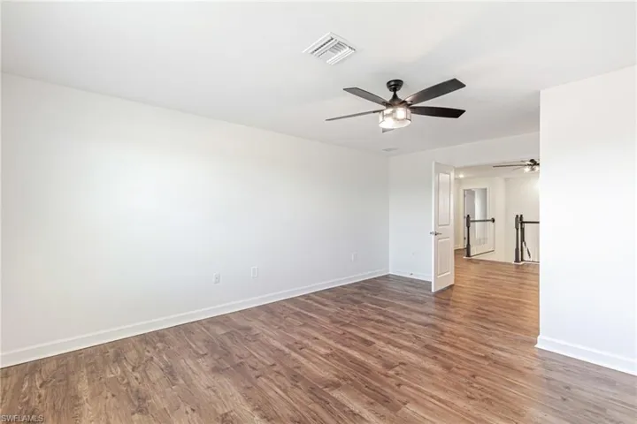 Spare room featuring dark wood-style floors and a ceiling fan
