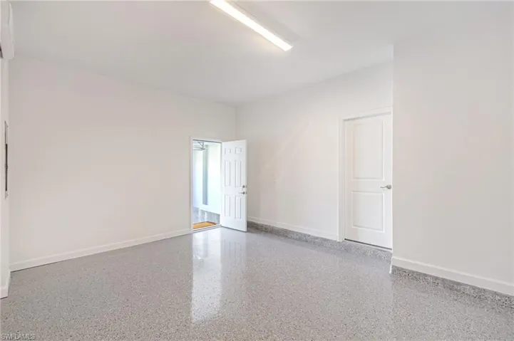 Spare room with baseboards and speckle patterned floor
