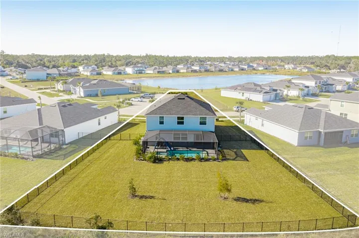 Aerial view of residential area featuring a nearby body of water