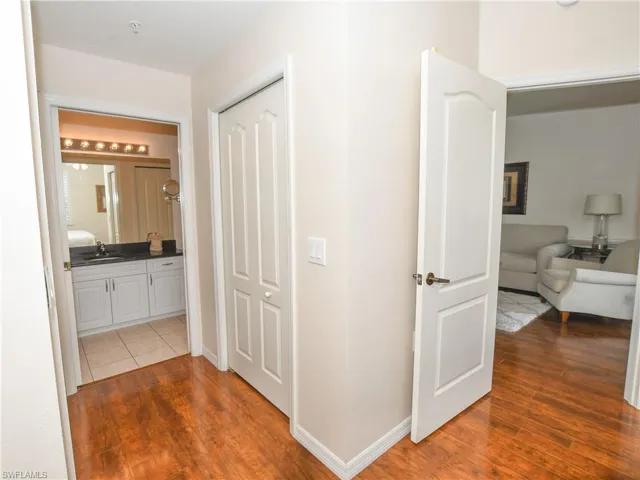 Corridor with a sink, baseboards, and wood finished floors