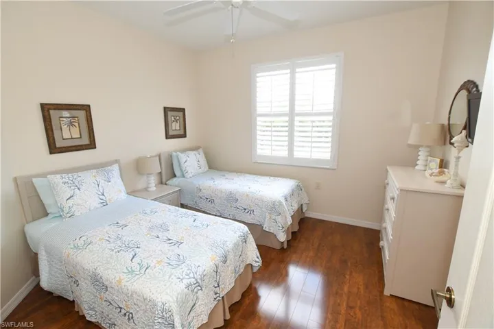 Bedroom featuring baseboards, ceiling fan, and dark wood-type flooring