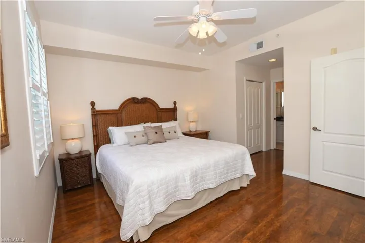 Bedroom featuring a closet, a ceiling fan, baseboards, visible vents, and dark wood-type flooring